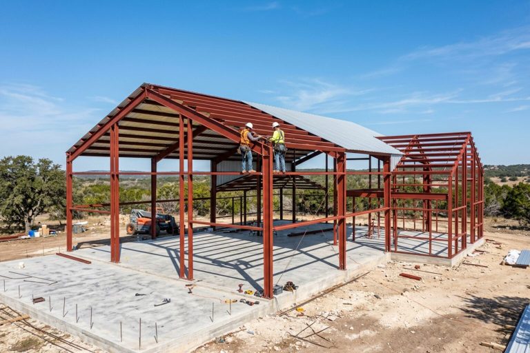 Steel barndominium frame going up on a slab in the Texas Hill Country